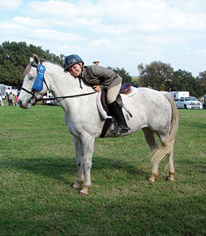 Little boy leaning on white horse