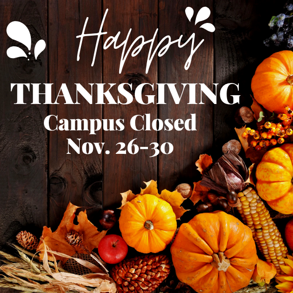  Graphic with a rustic wooden background and autumn decorations including pumpkins, corn, pinecones, and colorful leaves arranged along the bottom and right side. White text in the center reads: “Happy Thanksgiving. Campus Closed Nov. 26–30.” Decorative white accents appear near the word “Happy.”