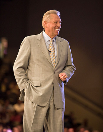John Maxwell Standing and Smiling