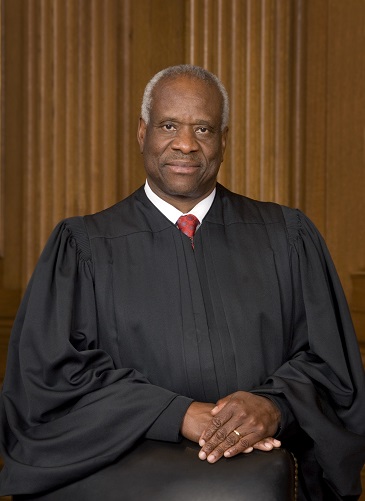 Portrait of Supreme Court Justice Clarence Thomas in judicial robes, seated with a neutral expression.