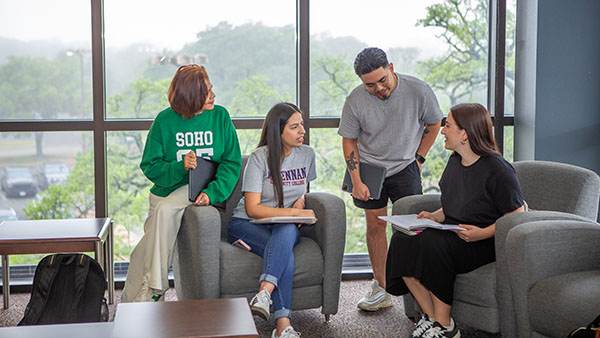 A group of students having a conversation in the MAC building.