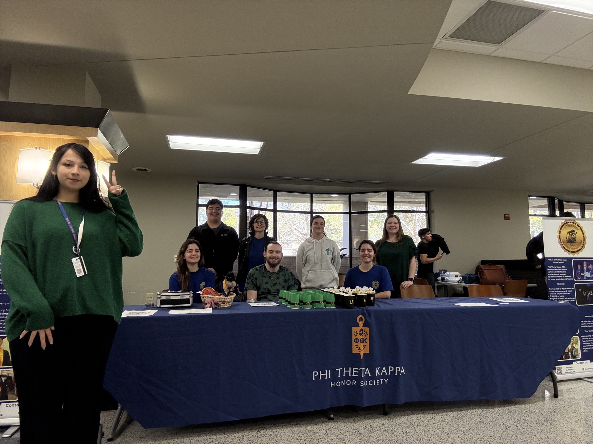 Pi Chi members sitting a fundraising table for St Patrick's Day