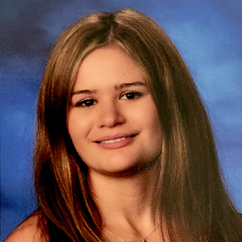 A portrait of a young woman with long brown hair and a friendly smile.