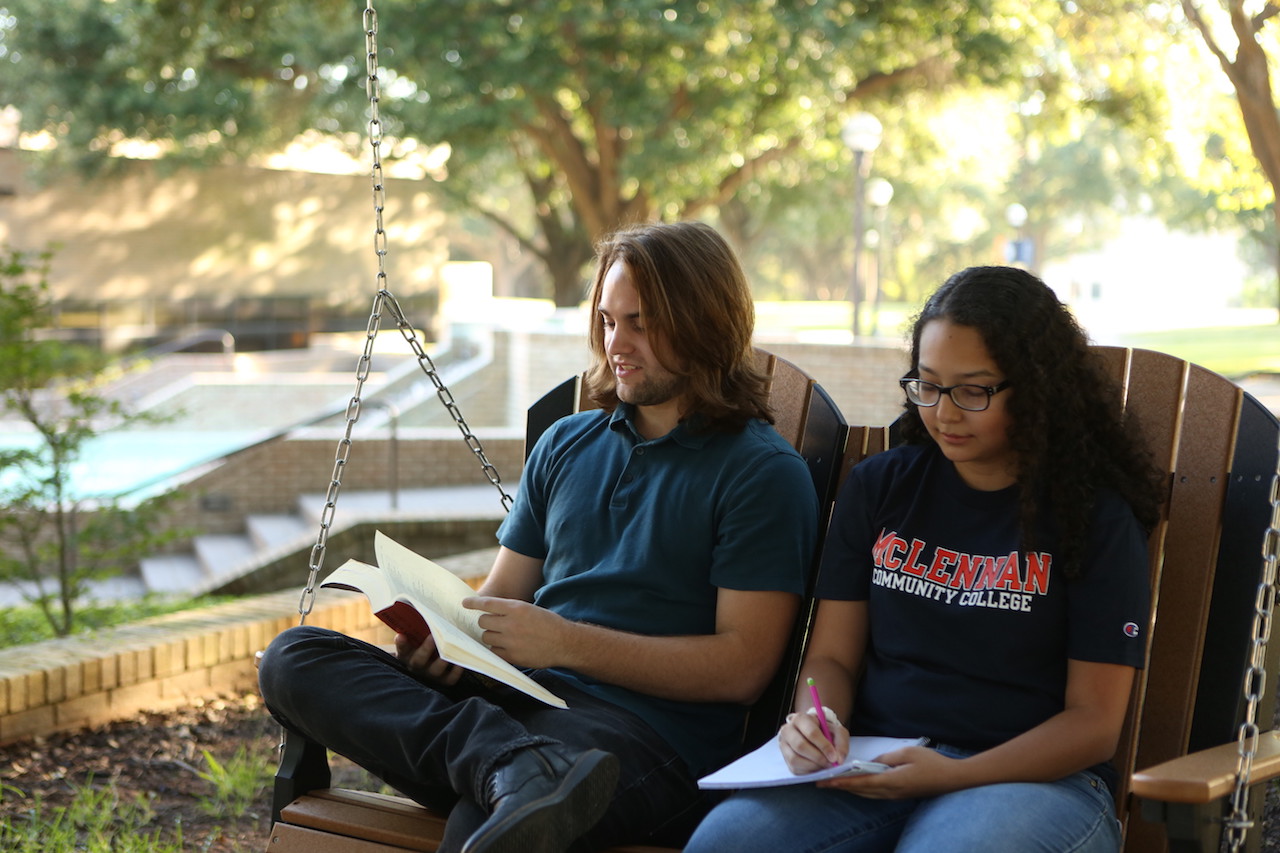Image of two students sitting on a swing,