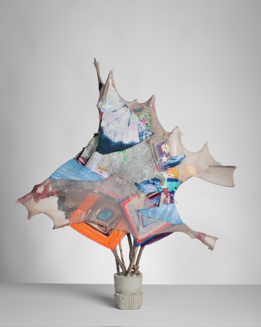 Abstract sculpture combining textiles and organic forms, highlighting a fusion of colors and textures.